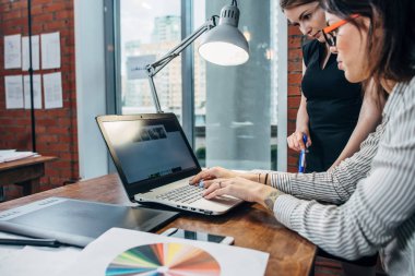 Dizüstü bilgisayar, grafik tablet, telefon ve renk paleti ile iç tasarımcı çalışma masasında görmek