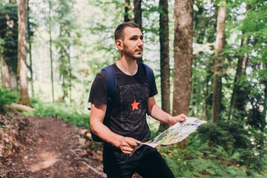 Yürüyüşçü ormanda hedef bulmak için bir harita kullanarak