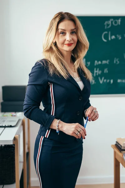 Portret van de jonge Kaukasische vrouwelijke leraar in de klas van de school — Stockfoto