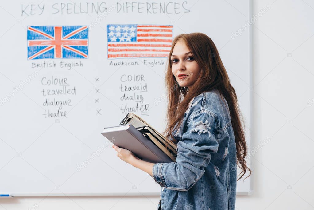 Female student with books in classroom English language school.