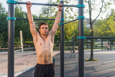 Duvar parmaklıklarına asılan Fitnes adamı. Çekirdek çapraz eğitim abs kasları çalışma