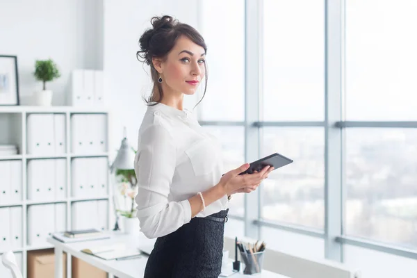 Portrét vedoucí kanceláře drží její tablet, psaní, wi-fi připojení k Internetu a aplikace dotykem na obrazovku pda. — Stock fotografie
