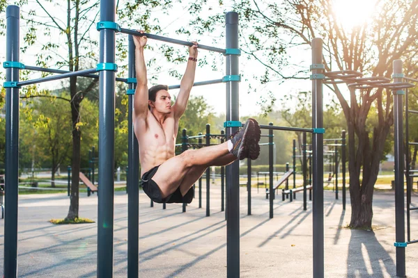 Sportler, die an einer Fitnessstation hängen und Beine hochlegen. Core Cross Training trainiert Bauchmuskeln — Stockfoto