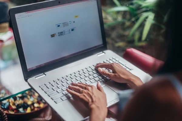 Retrato de una joven freelancer trabajando en una laptop sentada en una cafetería — Foto de Stock