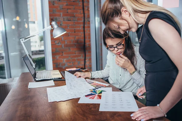 Creative team of graphic designers working on new project using color swatches and sketches of website elements design — Stock Photo, Image