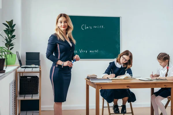 Leraar camera staande in de klas kijken — Stockfoto