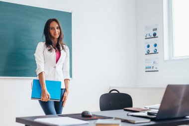 Genç öğretmen ya da gülümseyerek ve kameraya bakarak öğrenci.