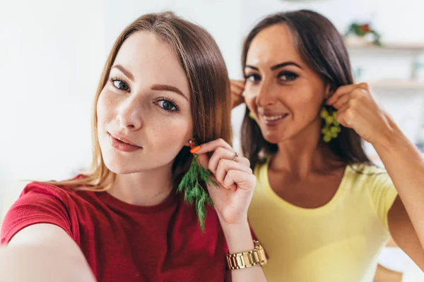 Amigos do sexo feminino tomando selfie enquanto faz café da manhã na cozinha . — Fotografia de Stock