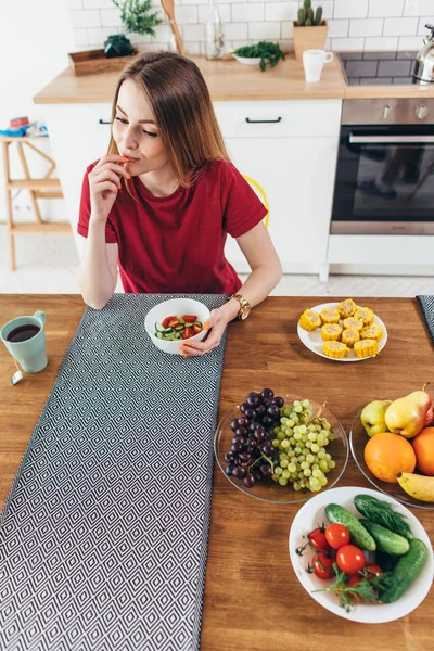 Mujer en casa comiendo frutas y verduras vista superior . — Foto de Stock