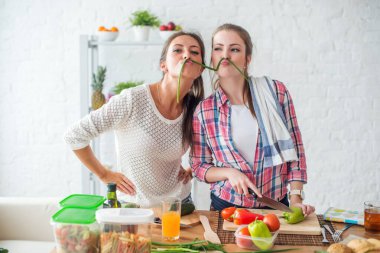 Kadınlar sağlıklı yiyecekler hazırlıyorlar mutfakta sebzelerle oynuyorlar beslenme konsepti oluşturuyorlar.