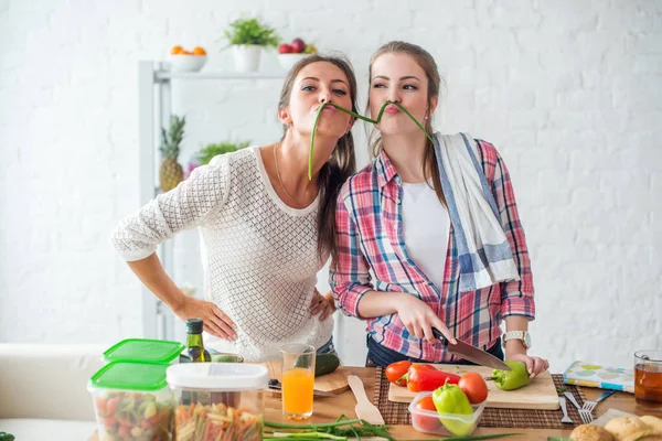 Femeile care pregătesc alimente sănătoase jucându-se cu legume în bucătărie având un concept distractiv de dietă — Fotografie, imagine de stoc