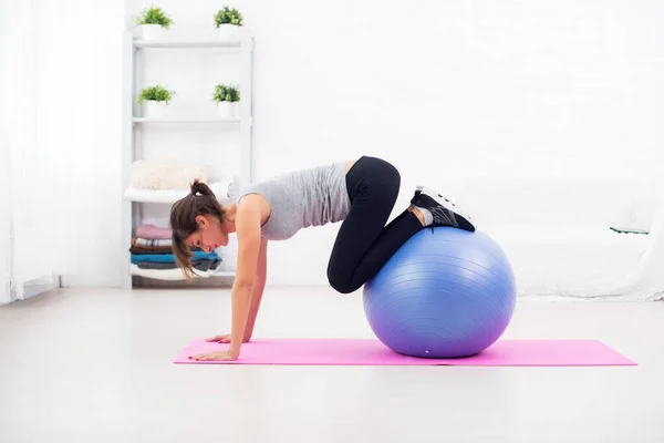 Sportiga kvinnan gör stretching fitness motion på boll — Stockfoto