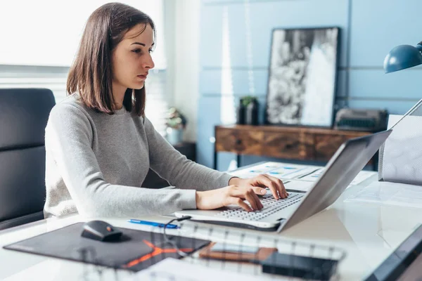 Donna che usa il computer portatile mentre è seduta alla scrivania. Imprenditrice in ufficio che lavora su laptop — Foto Stock