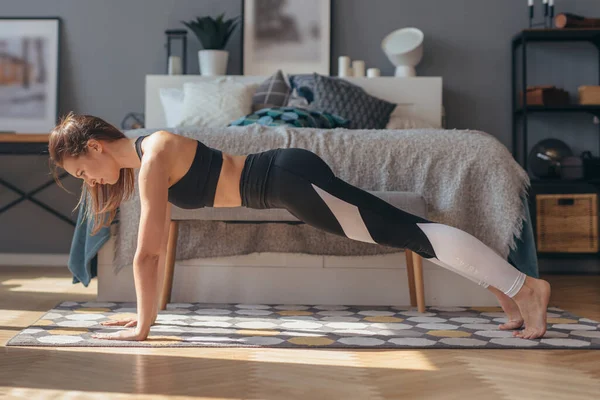 Pełna deska. Fitness kobieta ćwiczenia w domu. — Zdjęcie stockowe