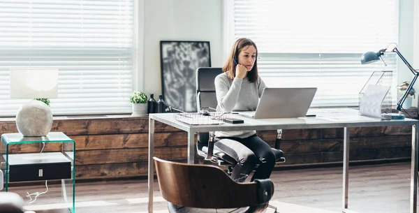 Ung kaukasisk kvinna arbetar på laptop i ämbetet. — Stockfoto