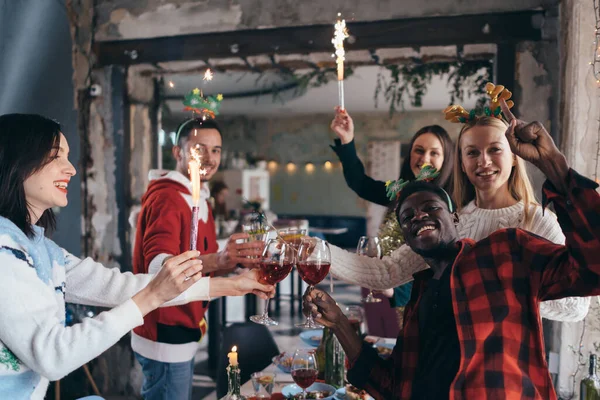 多民族の友人のワインを試飲。若い男性と女性がカフェでパーティーをしている。クリスマス. — ストック写真