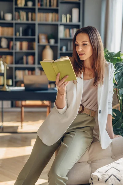 家で休んでいる女性の肖像と読書本上のソファ — ストック写真