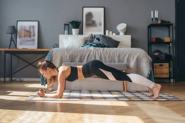 Formda bir kadın sabahları evde ön kol egzersizi yapıyor. — Stok fotoğraf
