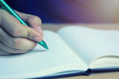 Yeşil kalem eğitim ve iş fikirleri iş sununuzdaki tasarımı için boş bir defter üzerinde bir adam elinde.