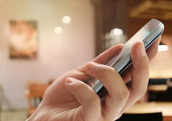 Adamın Elini Bir Smartphone Bulanıklık Restoran Arka Planda Tutan Tasarım — Stok fotoğraf