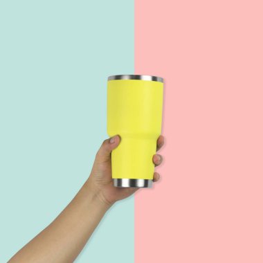 Bir bardak su sarı Vintage renk arka plan üzerinde tutan bir adamın elini.