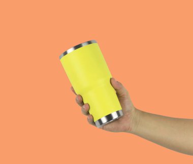 Bir bardak su sarı turuncu üzerinde tutan bir adamın elini arka plan renk ve kırpma yolları işlevi kullanımı kolay tasarımı için var.