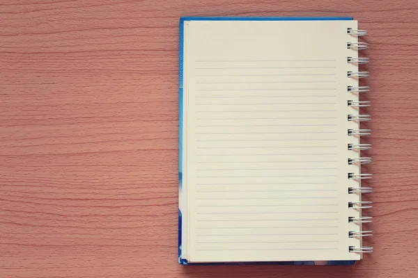 Boş kitap bir kahverengi ahşap zemin üzerine yerleştirilir ve iş kavramı tasarımında için kopya alanınız.