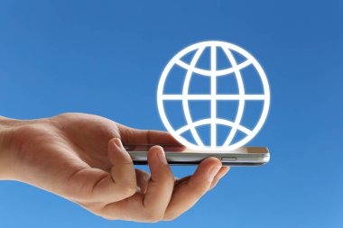 el bir smartphone ve dünya logosu mavi arka plan ve dijital çağın iletişim kavramı kopya uzayda var tutan işadamı.