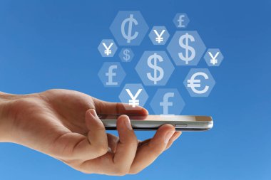 El iş kavramı tasarımında için mavi arka plan üzerinde bir smartphone ve finans simgesi tutan işadamı.