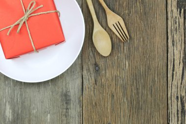 Kırmızı hediye kutusu beyaz ahşap zemin üzerinde çanak ve tahta kaşık Noel kavramı için var.