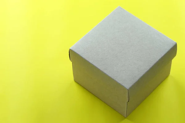 Caja Papel Marrón Descansa Sobre Piso Papel Amarillo Tiene Espacio — Foto de Stock