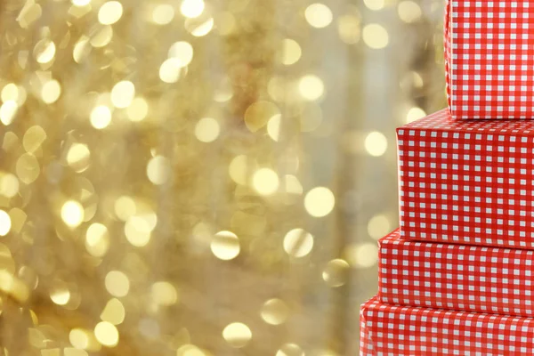 Red Gift Box on gold bokeh background of Christmas lights for design backdrop in your Christmas concept.