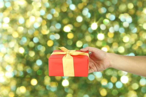Red Gift Box on hand for Christmas concept with green blur bokeh background for design in your work.