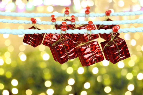 红色礼品盒挂在晾衣绳上的 Bokeh 背景设计在您的圣诞节概念 — 图库照片
