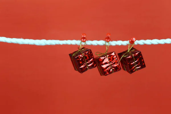 Red gift box hang on the clothesline and have copy space with clipping paths for design in your work.
