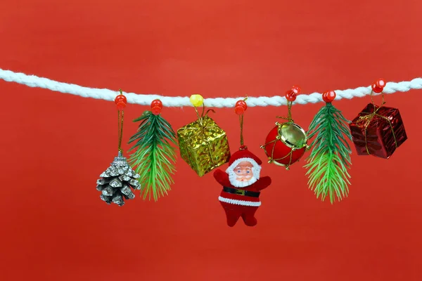 圣诞老人娃娃挂在晾衣绳上 并有复制空间与红色背景的设计在你的工作概念 — 图库照片