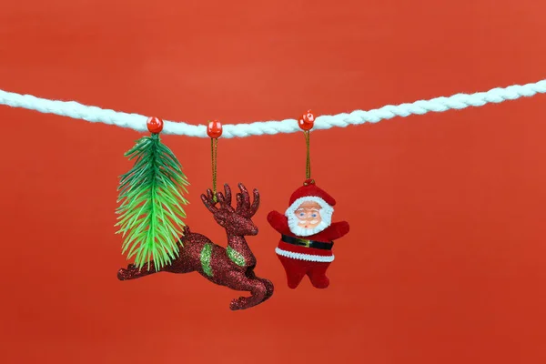 圣诞老人娃娃挂在晾衣绳上 并有复制空间与红色背景的设计在你的工作概念 — 图库照片
