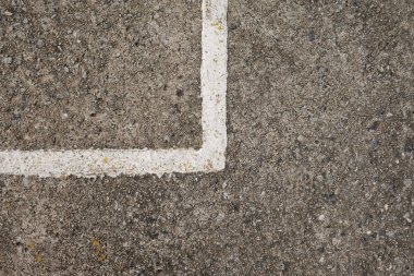 Sınır bölen beyaz çizgiler ile zemin beton ve kopya alanı var.