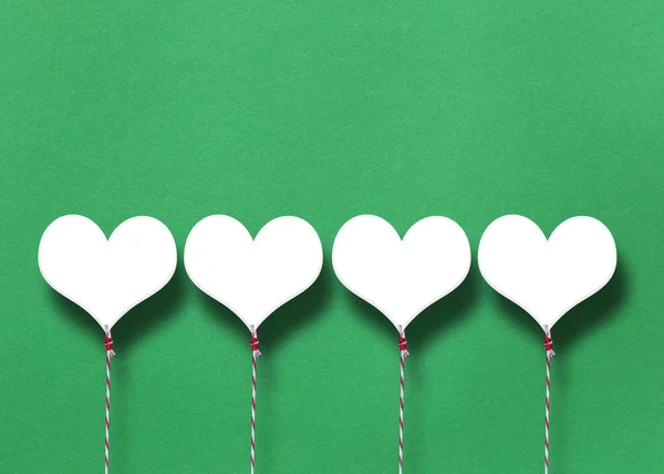 バレンタインの日の概念のための緑の紙背景に白いハート — ストック写真