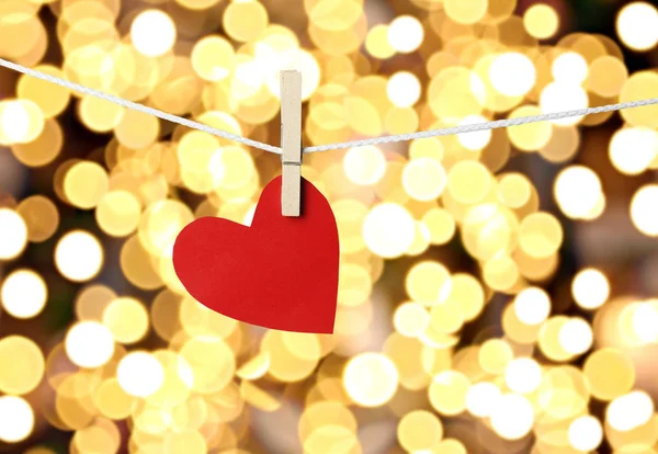 バレンタイン日概念と金背景のボケ味でロープにぶら下がっている赤い紙心 — ストック写真