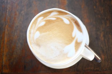 Ahşap gıdalar masada beyaz fincan latte kahve.