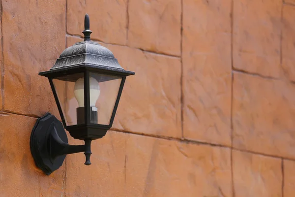 Modern black lamp hanging from the Brown brick wall. — Stock Photo, Image