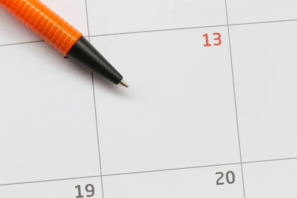 A caneta laranja é colocada no calendário no décimo terceiro dia e tem co — Fotografia de Stock