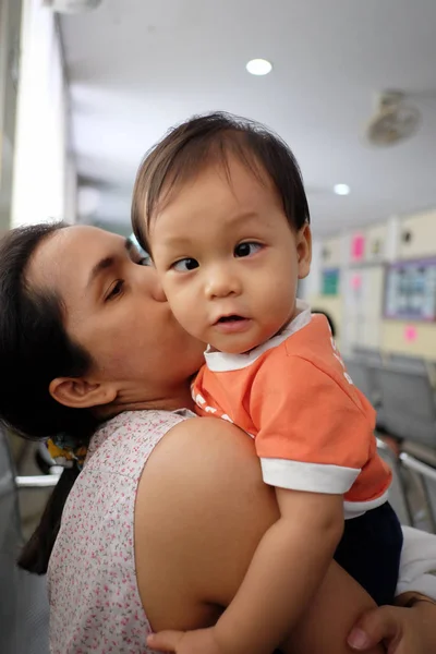 Aziatische moeder draagt een baby. — Stockfoto