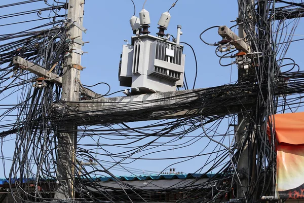 Los cables en los postes eléctricos están enredados, línea de señal desordenada . — Foto de Stock