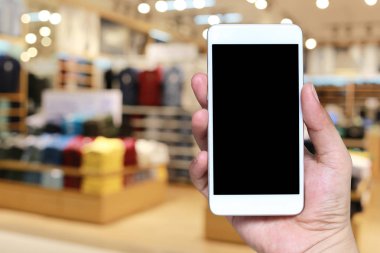 Bulanıklık içinde akıllı telefon cihazı tutan bir adamın eli Alışveriş mal