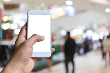 Bulanıklık içinde akıllı telefon cihazı tutan bir adamın eli Alışveriş mal