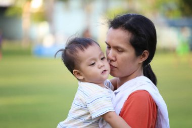 Asyalı çocuk, annesinin çocuklarına olan sevgisiyle yaşayabildiği için mutlu..