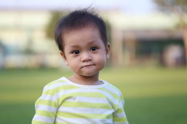 Asyalı çocuk bahçede yürümeyi öğreniyor, bebeğin şirinliği..