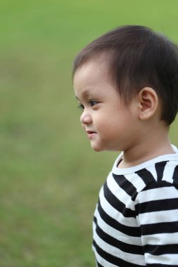 Asyalı çocuk bahçede yürümeyi öğreniyor, bebeğin şirinliği..